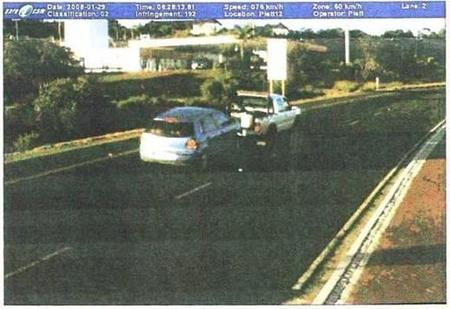 Photograph of a tow-truck towing a car down a road.